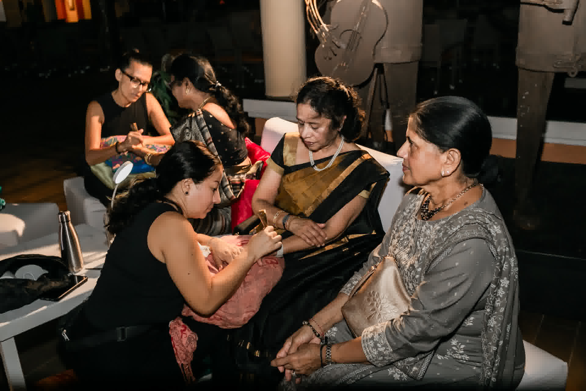 Family members taking part in a Mehndi celebration photographed by Xavier Bau Weddings