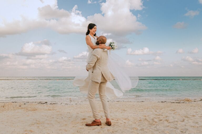 Kishory embracing Kyle as he lifts her above the sand.