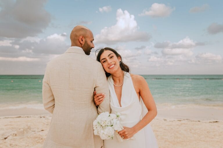 Kishory smiling toward the camera while embracing Kyle beside the sea.