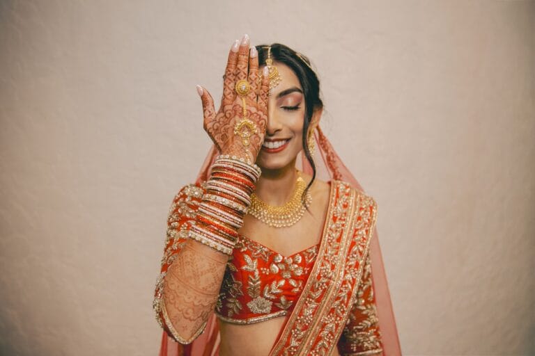 Kishory showing her henna-decorated hand, bangles and bridal jewelry.