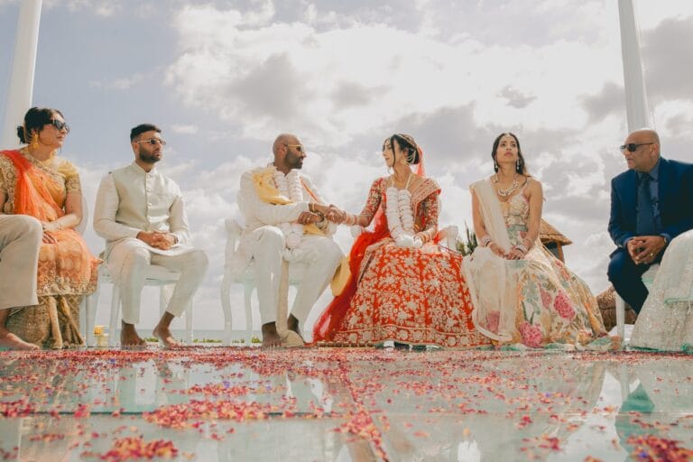 Kyle and Kishory seated beneath the mandap with guests beside them.
