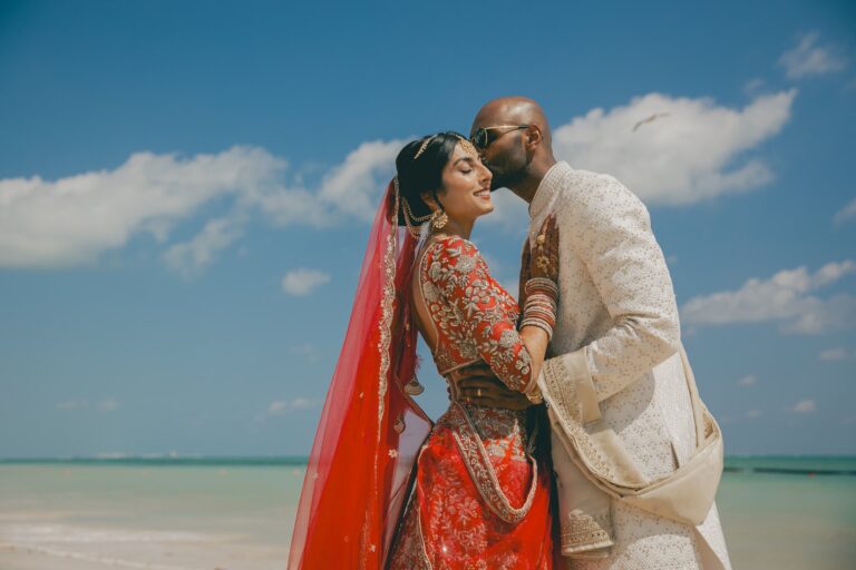 Kyle kissing Kishory’s forehead during their portraits in Indian wedding attire.