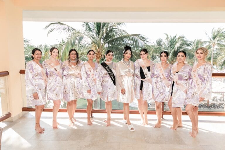 Nusaibah and her bridal party in matching robes on a palm-lined terrace at Barcelo Riviera Maya.