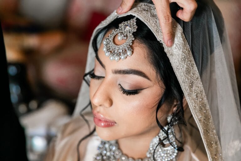 Close-up of Nusaibah as her embroidered bridal veil is adjusted at Barcelo Riviera Maya.