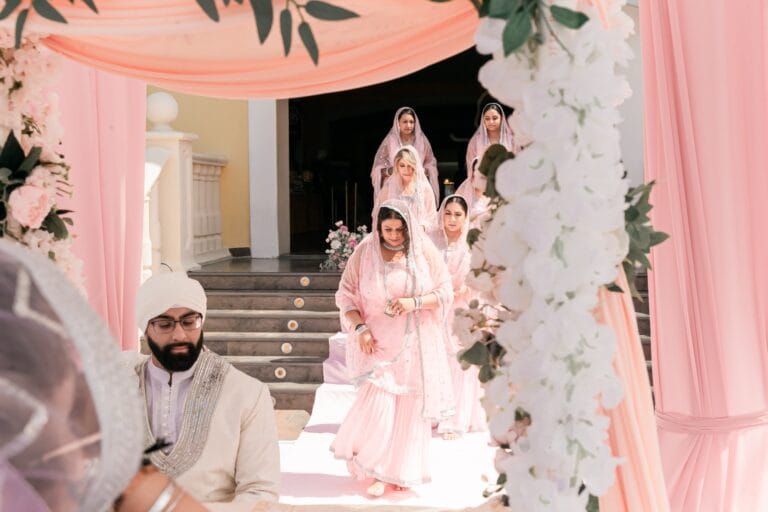 Nusaibah arriving at the flower-decorated outdoor ceremony with guests at Barcelo Riviera Maya.