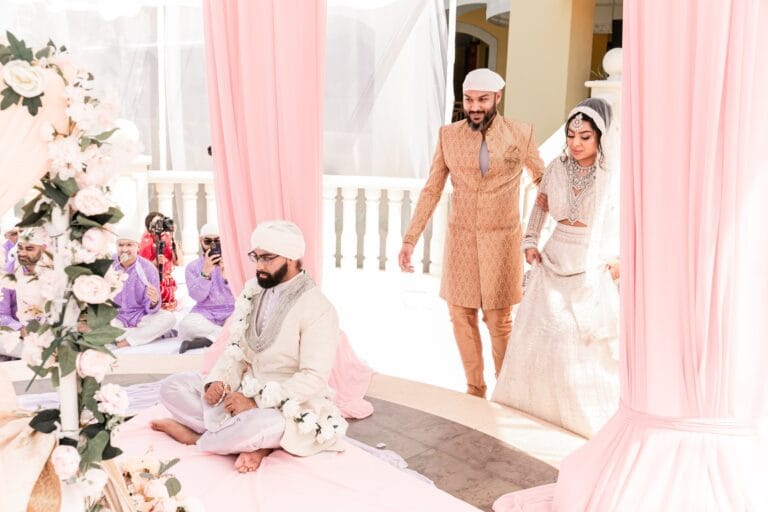 Jai seated at the ceremony as Nusaibah stands nearby at Barcelo Riviera Maya.