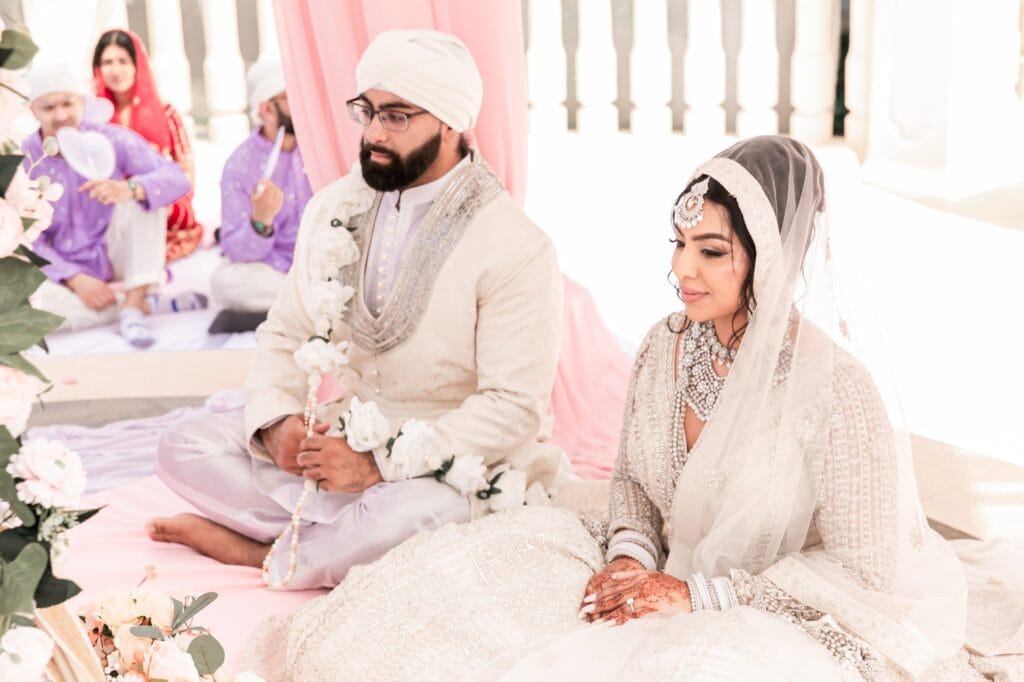 Nusaibah and Jai seated together during their Sikh ceremony at Barcelo Riviera Maya.