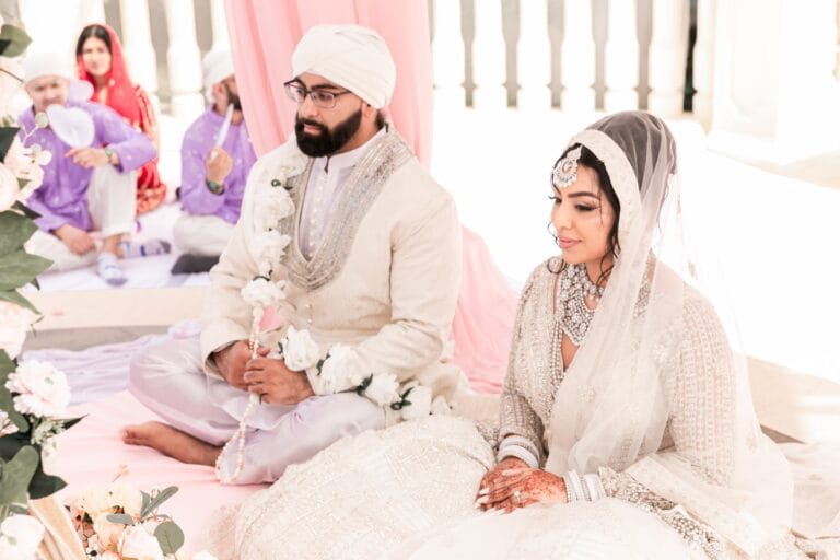 Nusaibah and Jai seated together during their Sikh ceremony at Barcelo Riviera Maya.