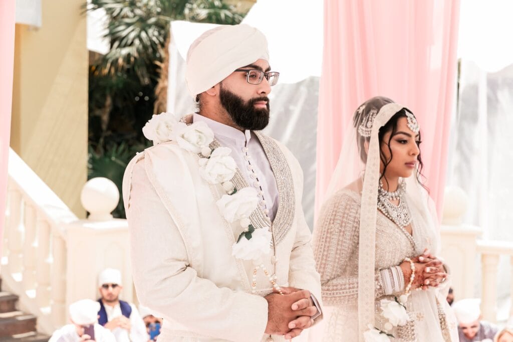 Close portrait of Nusaibah and Jai standing together during the ceremony at Barcelo Riviera Maya.
