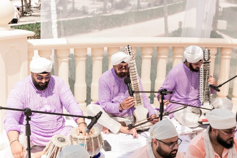 Three musicians performing beside the outdoor wedding ceremony at Barcelo Riviera Maya.