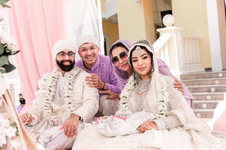 Nusaibah and Jai posing with two wedding guests at the ceremony at Barcelo Riviera Maya.