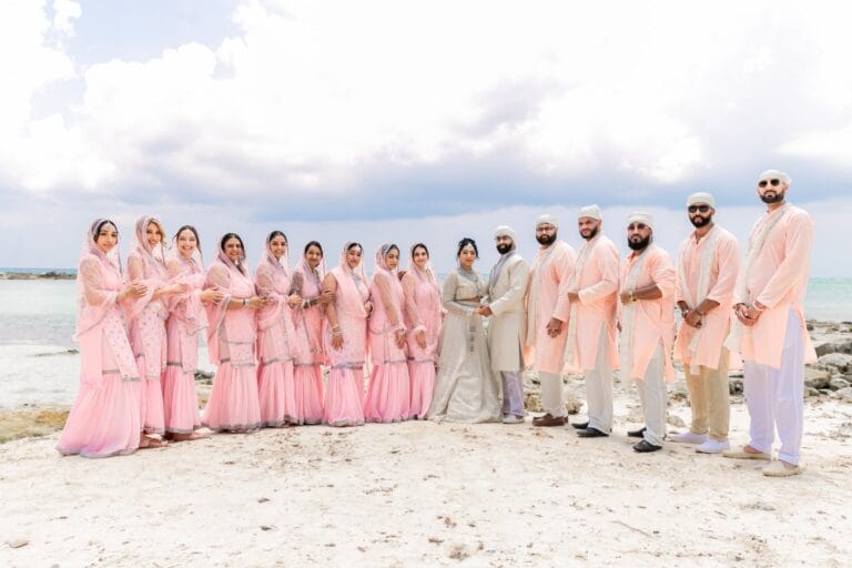 Nusaibah and Jai with their wedding party on the Caribbean shoreline at Barcelo Riviera Maya.