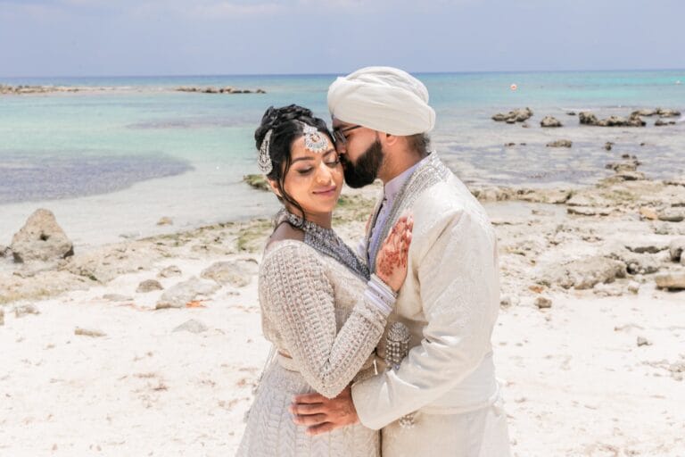 Nusaibah and Jai embracing during their beachfront wedding portraits at Barcelo Riviera Maya.
