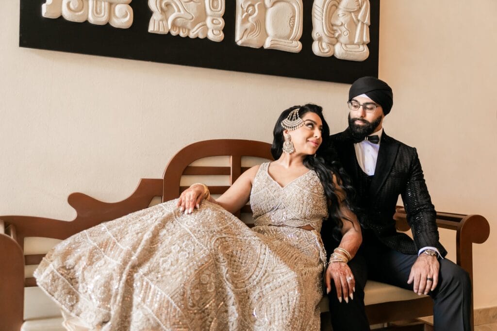 Nusaibah and Jai seated together in their evening wedding attire at Barcelo Riviera Maya.