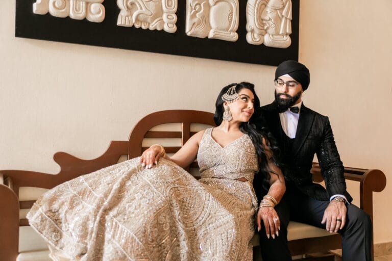 Nusaibah and Jai seated together in their evening wedding attire at Barcelo Riviera Maya.