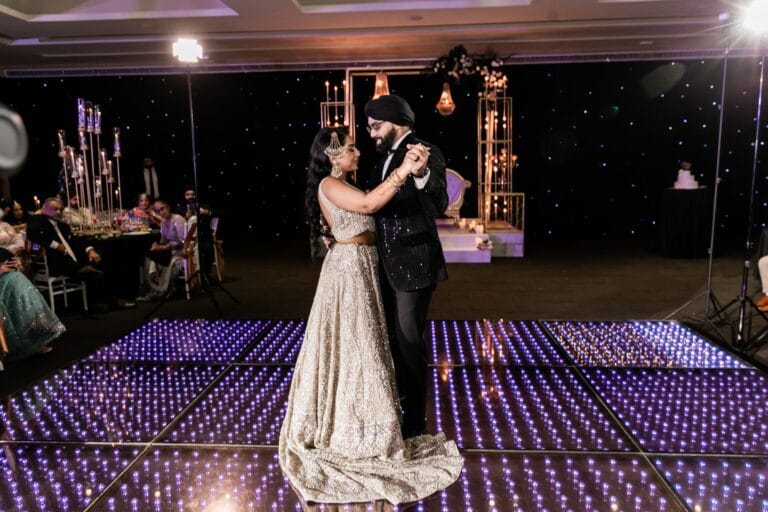 Nusaibah and Jai dancing together on an illuminated reception floor at Barcelo Riviera Maya.