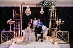 Nusaibah and Jai posing with guests at their decorated reception seating at Barcelo Riviera Maya.