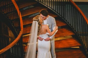Sarah and Gunnar embracing on the curved wooden staircase